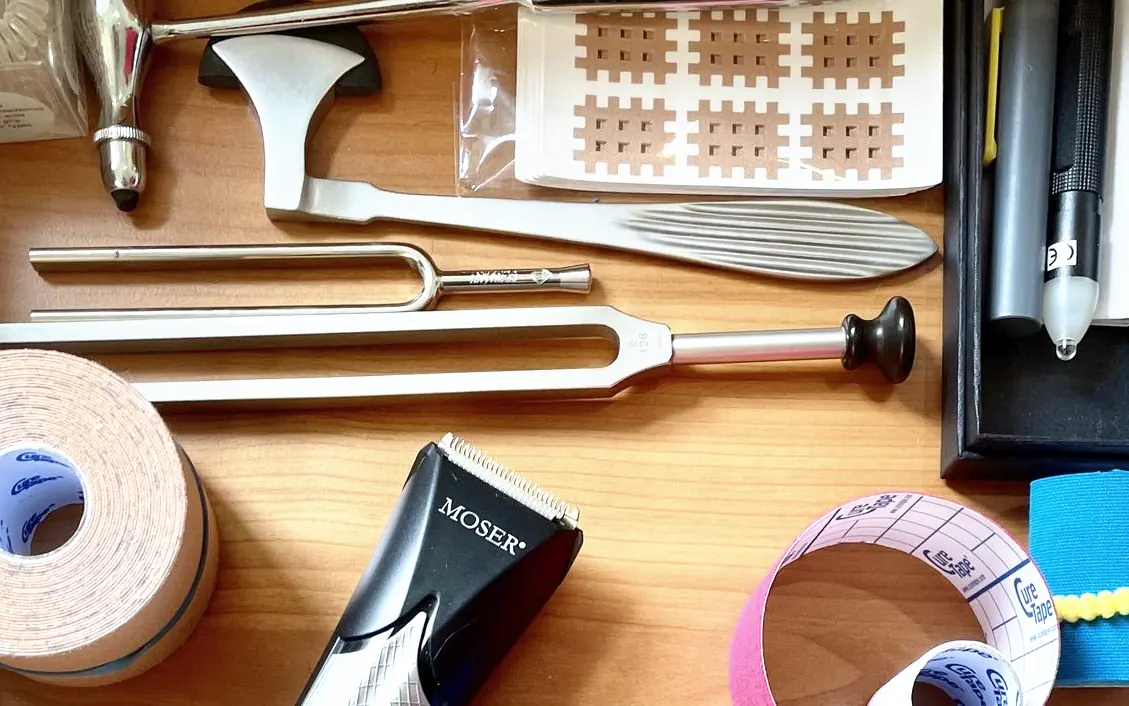 Stimmgabel, Kreuz-Tapes und Tape-Rollen auf einem Holztisch